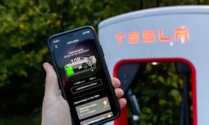 tesla-supercharging-in-the-smartphone-app-held-in-front-a-tesla-charging-station