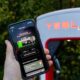 tesla-supercharging-in-the-smartphone-app-held-in-front-a-tesla-charging-station